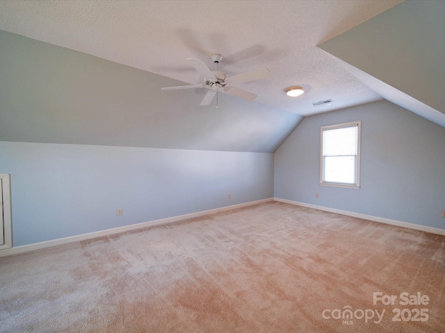 bonus room with a textured ceiling, light colored carpet, ceiling fan, and lofted ceiling