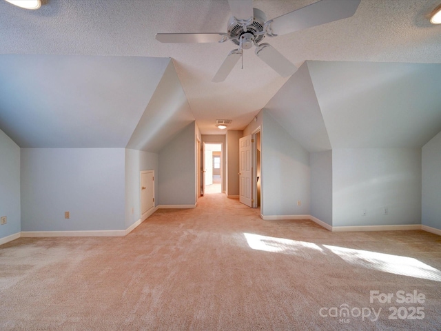 bonus room with light carpet, a textured ceiling, ceiling fan, and lofted ceiling