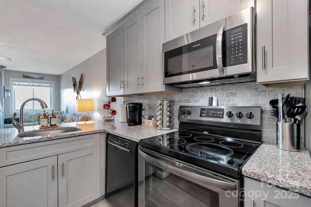 kitchen featuring decorative backsplash, gray cabinets, sink, and stainless steel appliances