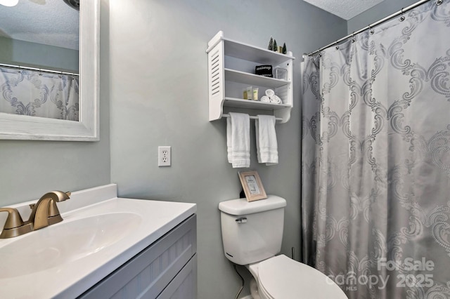 bathroom with vanity, a shower with shower curtain, a textured ceiling, and toilet