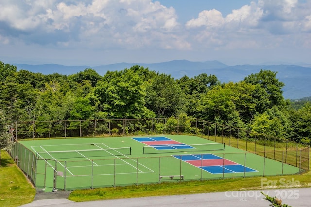 view of tennis court featuring a mountain view