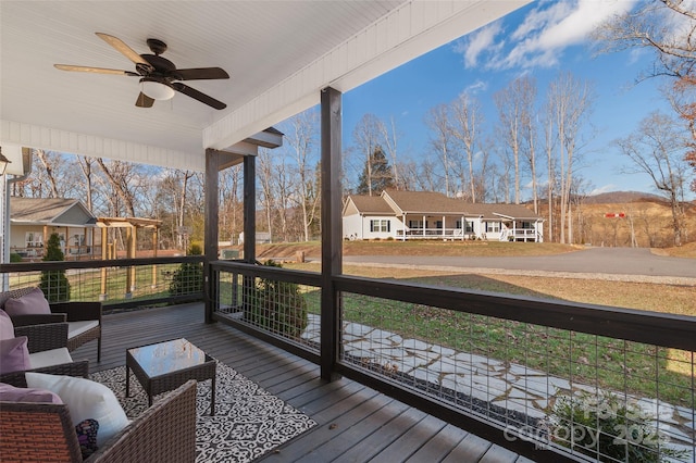 deck featuring outdoor lounge area, ceiling fan, and covered porch