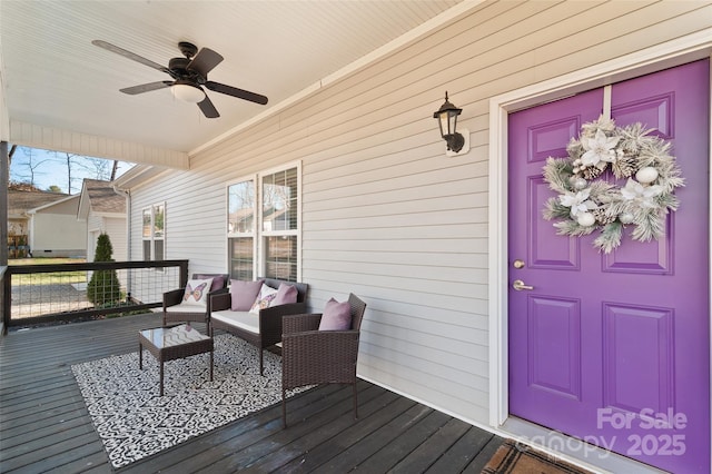 wooden deck featuring outdoor lounge area and ceiling fan