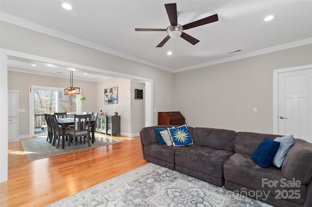 living room featuring ceiling fan, hardwood / wood-style floors, and crown molding