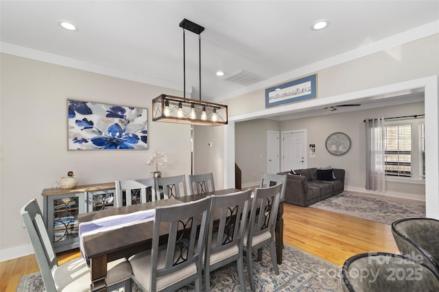 dining room with crown molding and hardwood / wood-style flooring