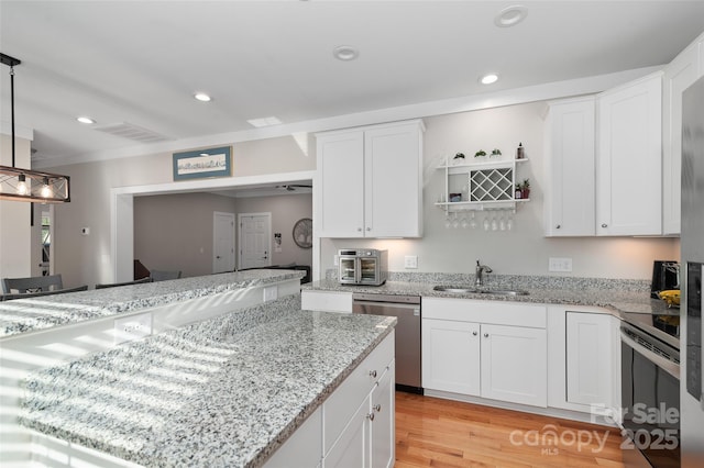 kitchen with white cabinets, dishwasher, stove, and hanging light fixtures