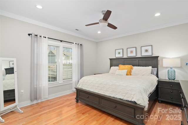 bedroom featuring ceiling fan, light wood-type flooring, and crown molding