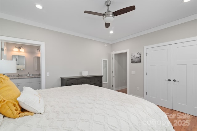 bedroom featuring connected bathroom, ceiling fan, light hardwood / wood-style flooring, a closet, and ornamental molding