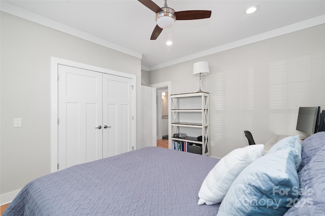 bedroom featuring hardwood / wood-style flooring, ceiling fan, crown molding, and a closet