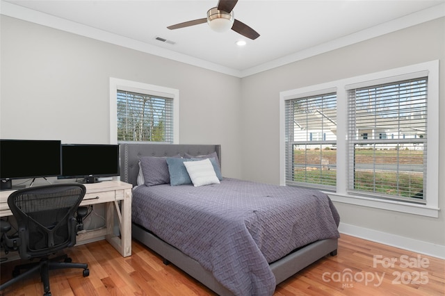 bedroom with ceiling fan, wood-type flooring, crown molding, and multiple windows