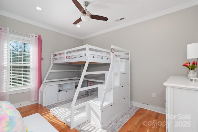 bedroom with light hardwood / wood-style flooring, ceiling fan, and ornamental molding