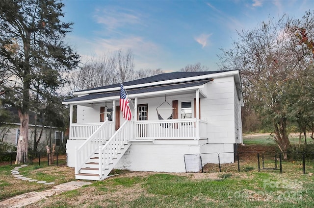 view of front of property with a porch and a front lawn