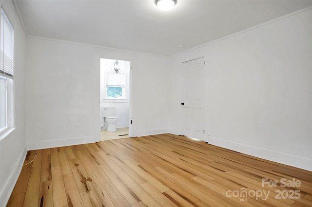 spare room with hardwood / wood-style floors and ornamental molding