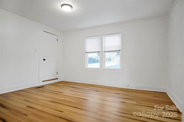 spare room featuring hardwood / wood-style flooring and ornamental molding