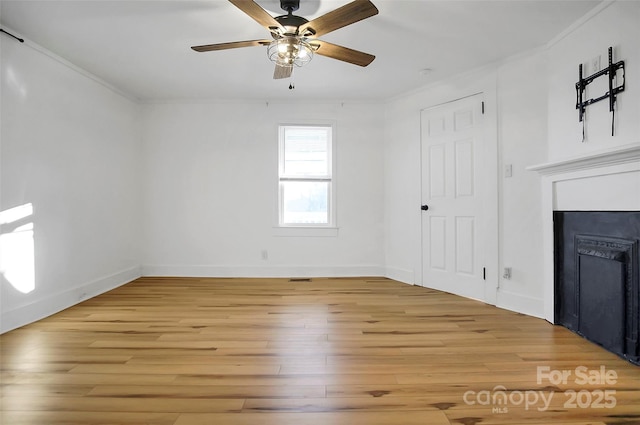 unfurnished living room with light hardwood / wood-style floors, ceiling fan, and ornamental molding