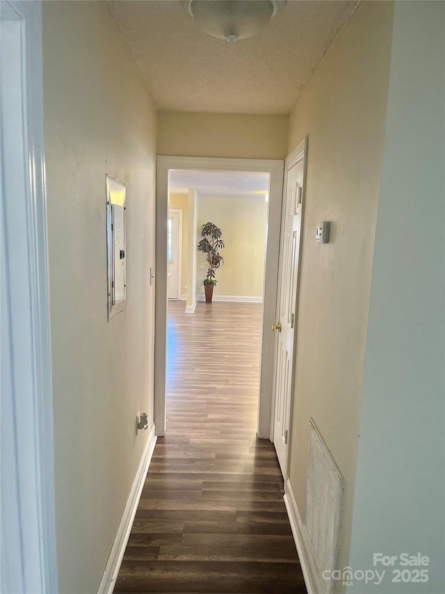 corridor featuring dark hardwood / wood-style floors and a textured ceiling