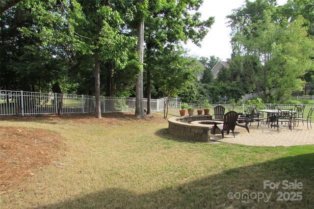 view of yard featuring a fenced backyard, an outdoor fire pit, and a patio area