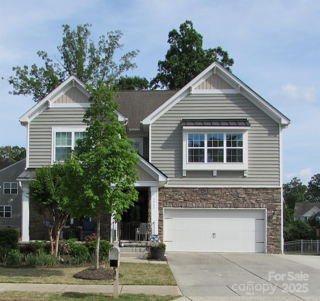 craftsman house with concrete driveway, an attached garage, and stone siding
