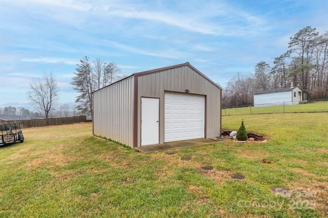 view of outdoor structure with a garage and a lawn