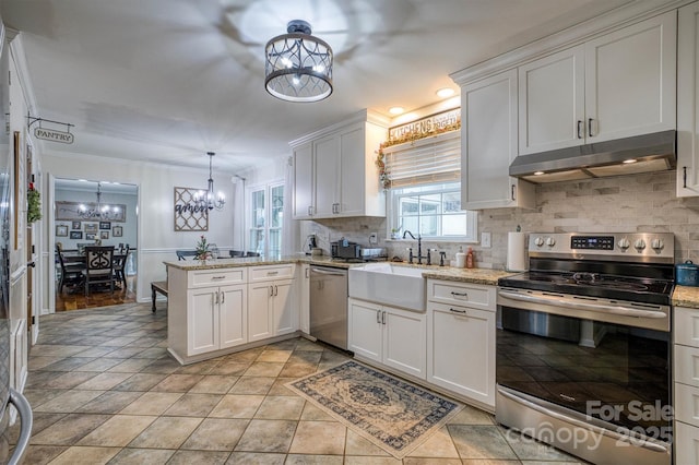 kitchen with decorative light fixtures, white cabinetry, and stainless steel appliances