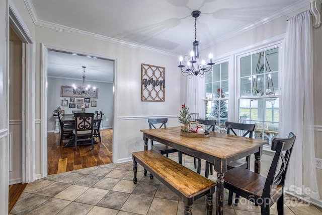 dining space with crown molding and a chandelier