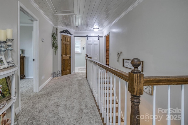 hallway with light colored carpet, ornamental molding, wood ceiling, and a barn door