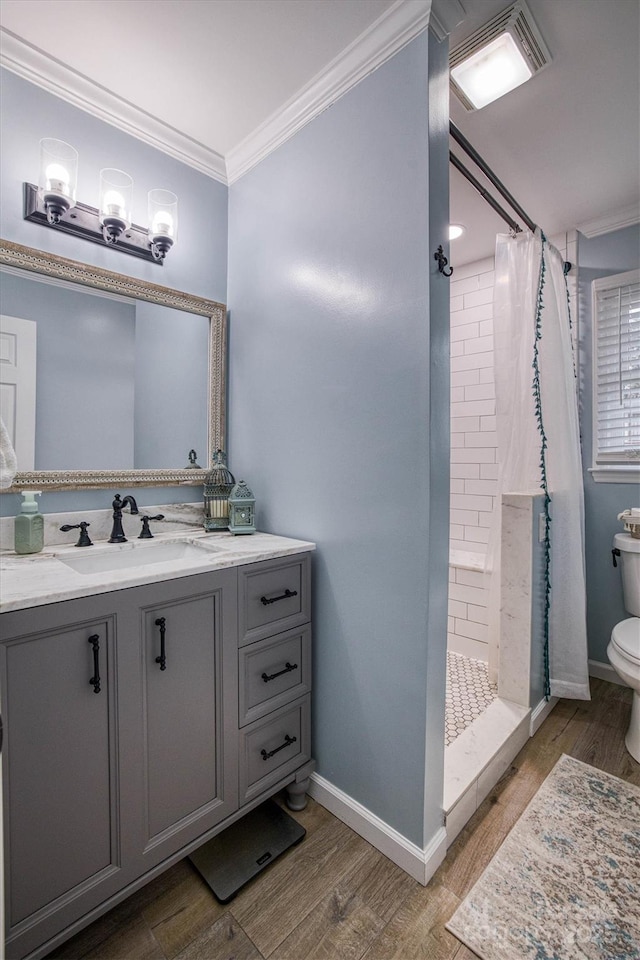 bathroom with toilet, vanity, crown molding, and a shower with shower curtain