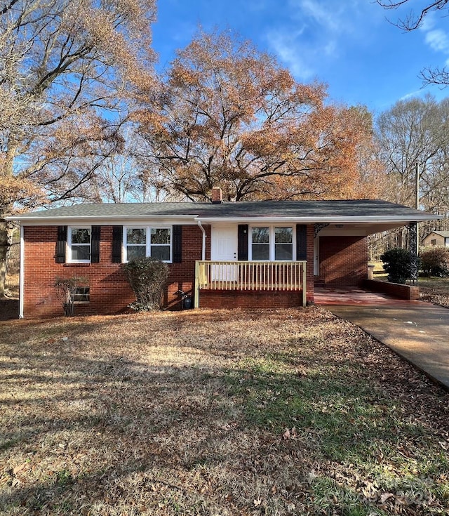 ranch-style house featuring a carport, concrete driveway, brick siding, and a chimney