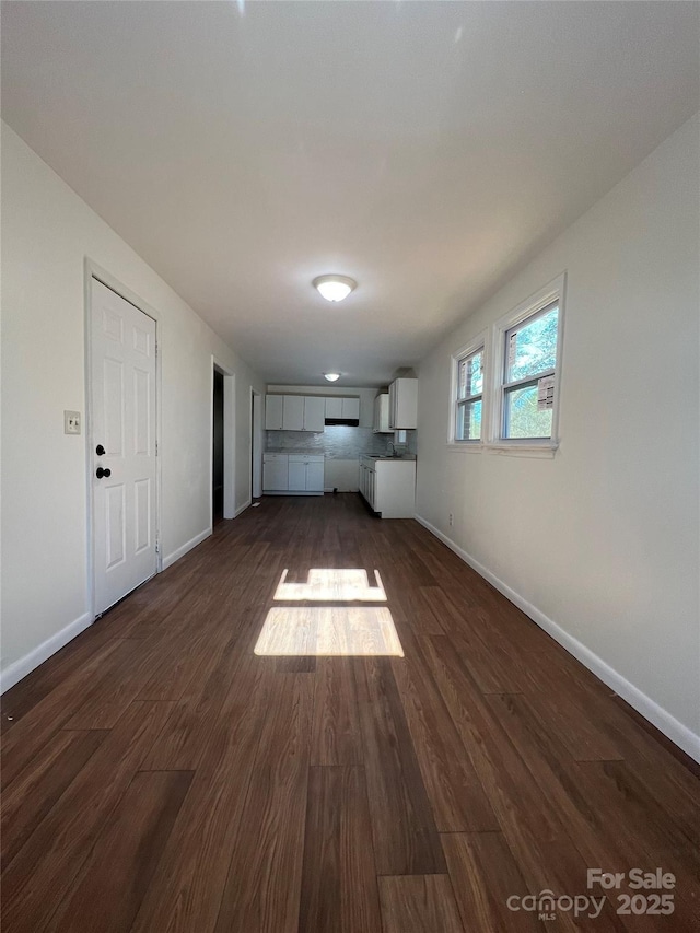 unfurnished living room with dark wood-type flooring