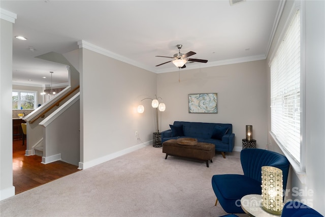 carpeted living room featuring ceiling fan and ornamental molding