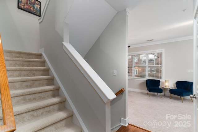 staircase with carpet floors and ornamental molding