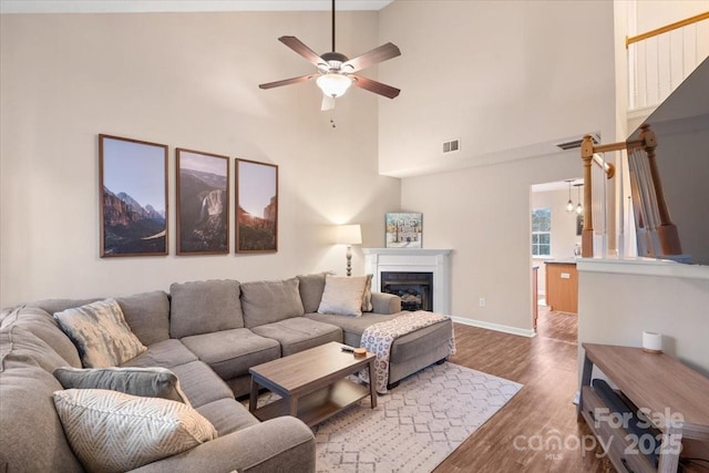 living room featuring ceiling fan, dark wood-type flooring, and high vaulted ceiling