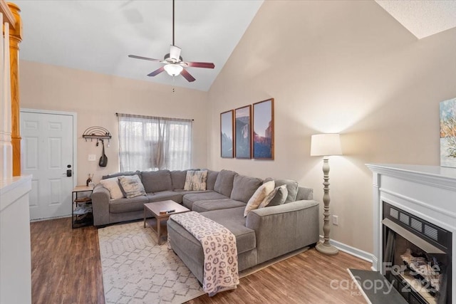 living room featuring hardwood / wood-style floors, ceiling fan, and high vaulted ceiling