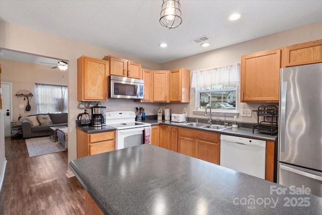 kitchen with ceiling fan, sink, dark wood-type flooring, a textured ceiling, and appliances with stainless steel finishes