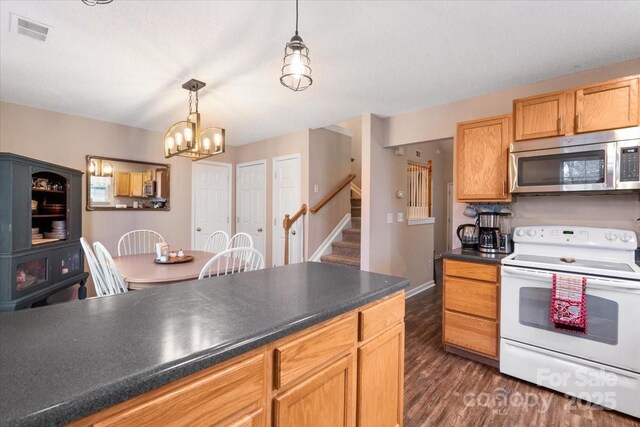 kitchen featuring a textured ceiling, electric stove, decorative light fixtures, a notable chandelier, and dark hardwood / wood-style floors