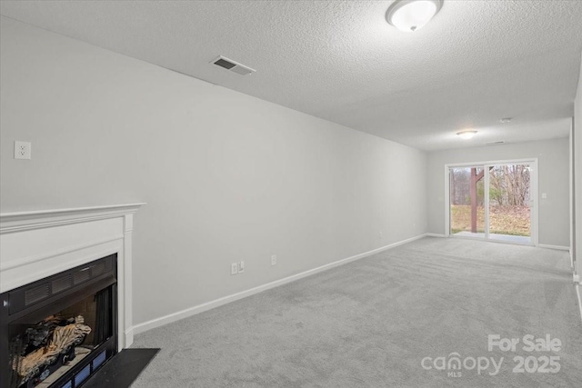 unfurnished living room with carpet and a textured ceiling