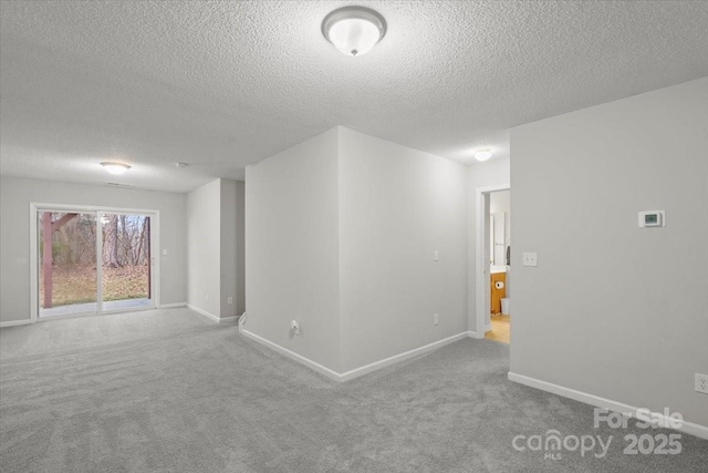 empty room featuring a textured ceiling and carpet floors