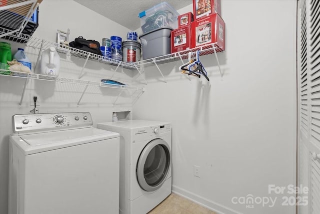 washroom with a textured ceiling and separate washer and dryer