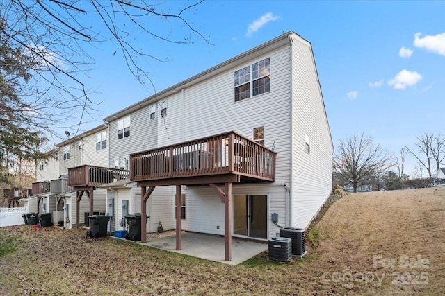 rear view of property with a lawn, cooling unit, a deck, and a patio