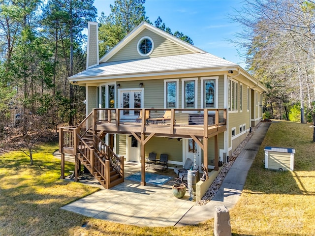 back of house with a lawn, a patio area, french doors, and a wooden deck