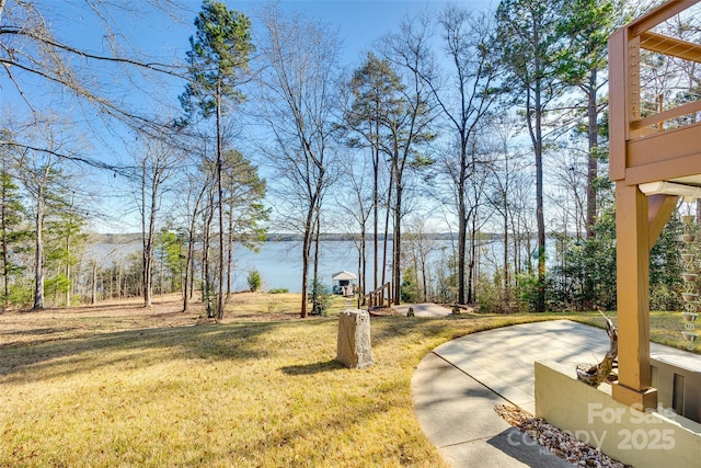 view of yard with a water view and a patio area