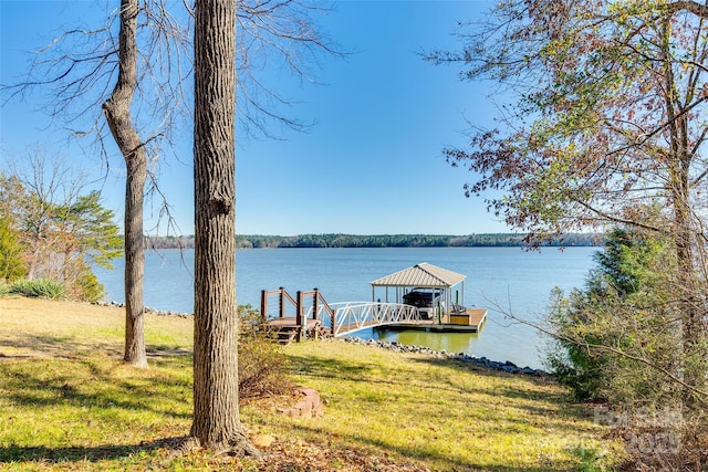 view of dock featuring a water view and a lawn