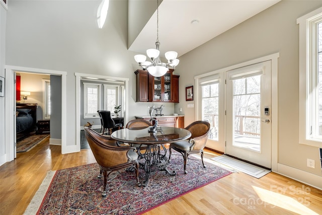 dining room featuring an inviting chandelier, a healthy amount of sunlight, and light wood-type flooring