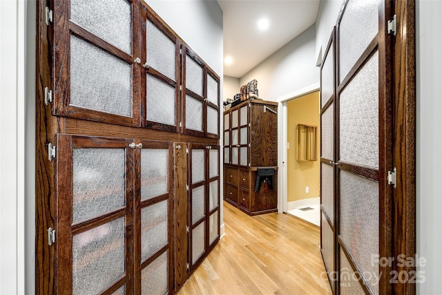 hall with french doors and light hardwood / wood-style flooring