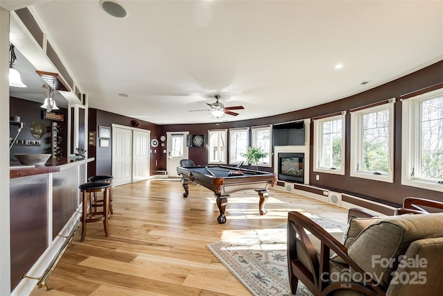 playroom featuring pool table, a healthy amount of sunlight, light wood-type flooring, and bar