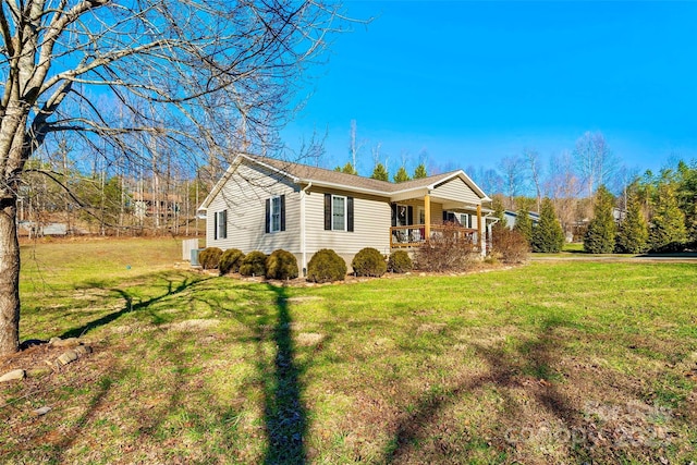 ranch-style home featuring covered porch and a front yard