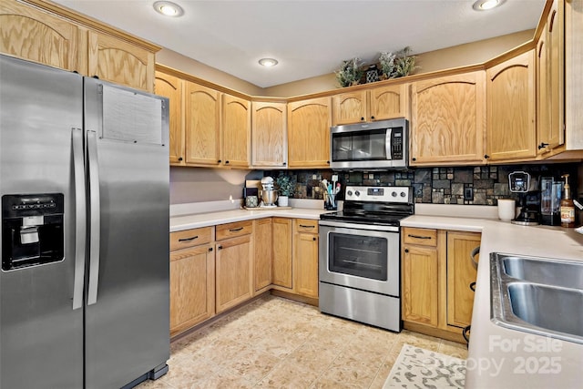 kitchen with backsplash, sink, and stainless steel appliances