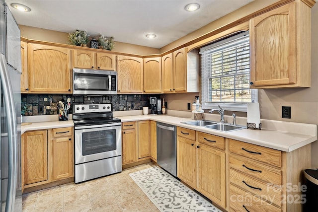 kitchen with sink, stainless steel appliances, decorative backsplash, light brown cabinetry, and light tile patterned flooring