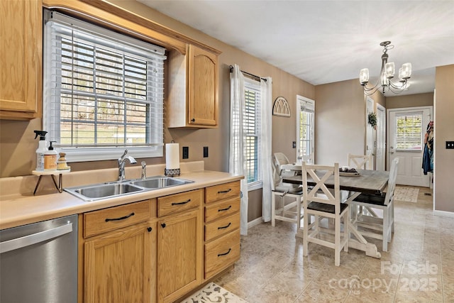 kitchen with pendant lighting, sink, stainless steel dishwasher, light brown cabinetry, and a chandelier