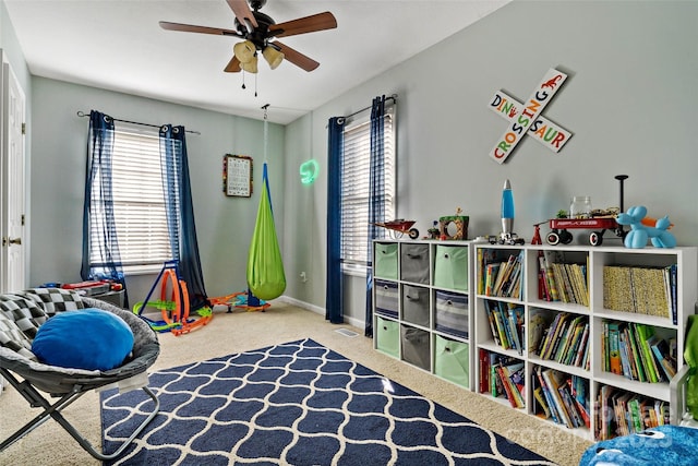 recreation room featuring ceiling fan, carpet floors, and a healthy amount of sunlight